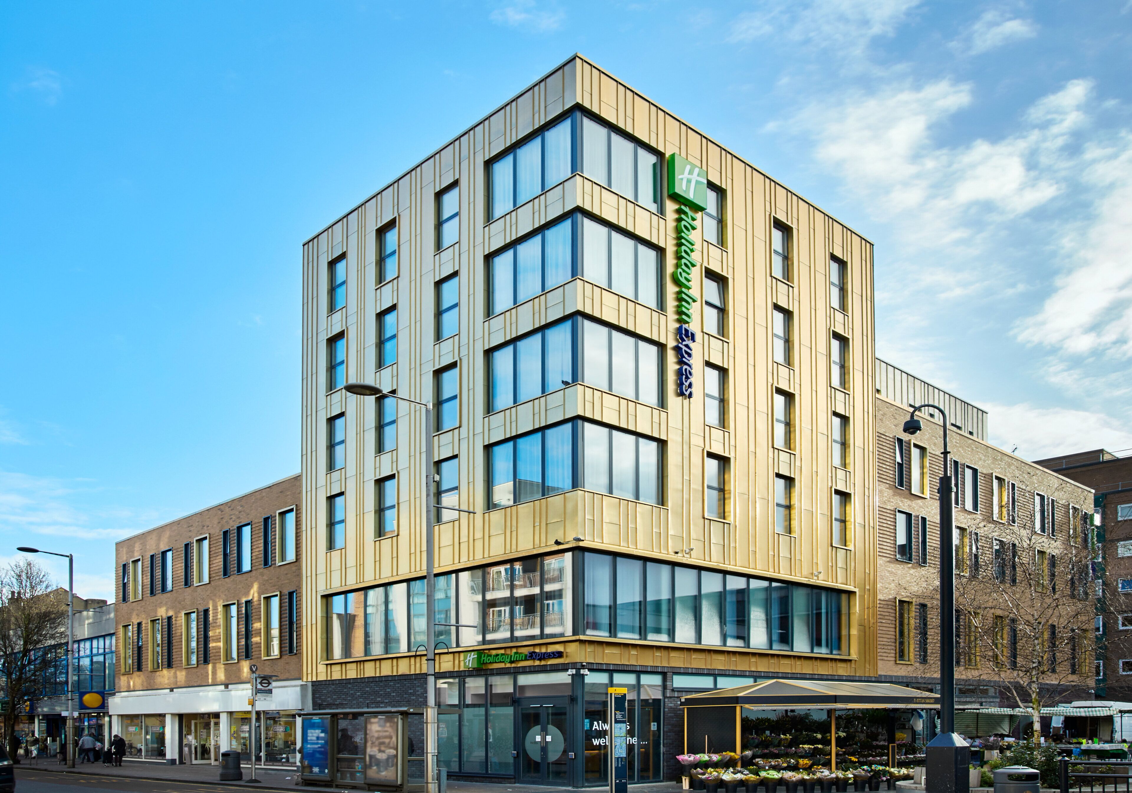 Um edifício moderno do Holiday Inn Express com vários andares, grandes janelas e entrada visível.