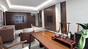 A modern interior with a dining area, kitchen, and seating. - Fenghua International Garden Hotel (Dongying)