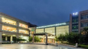 The exterior of the Blue Horizon Center Point Hotel with a clear entrance and a parking area. - Fenghua International Garden Hotel (Dongying)