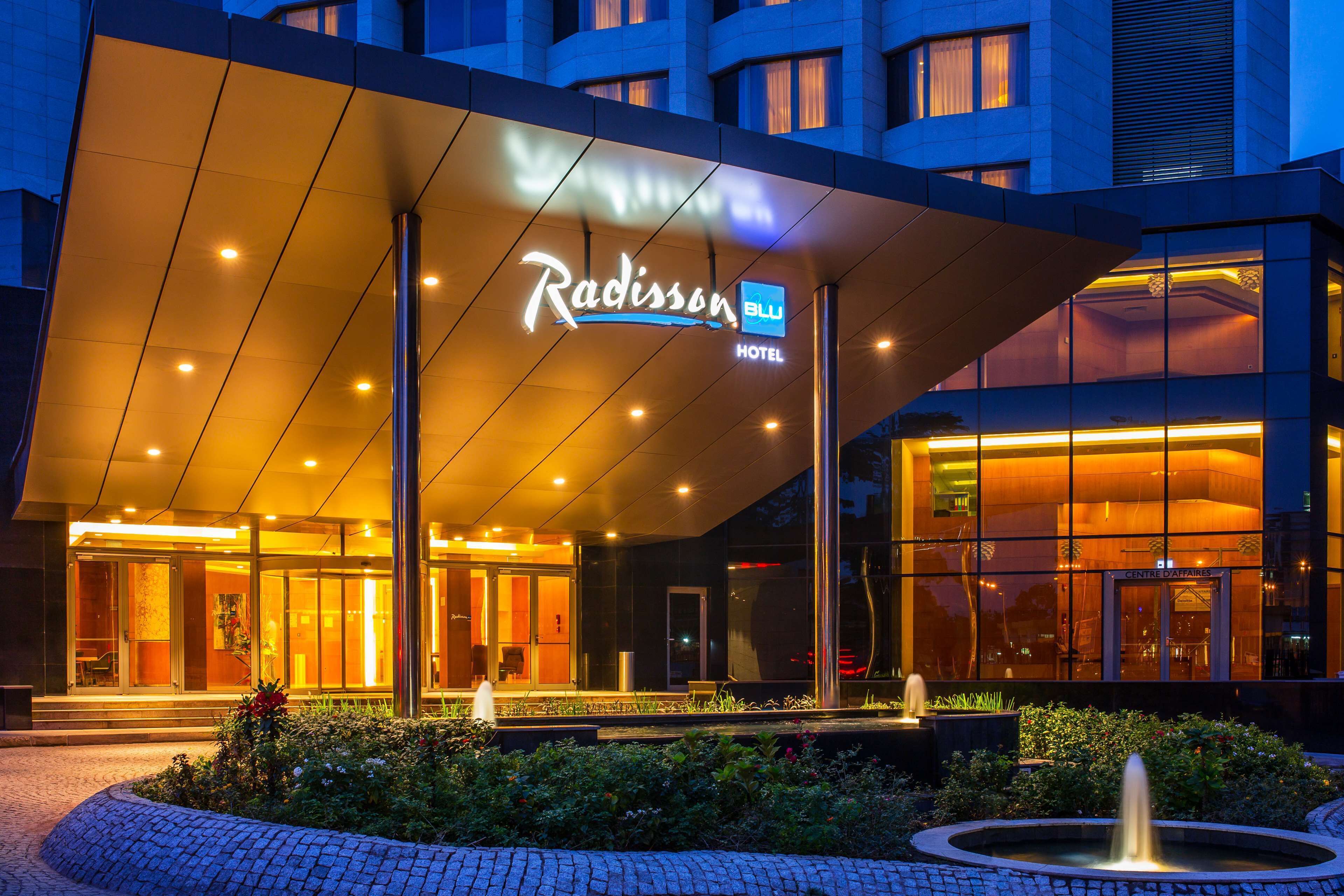 Der Eingang des Radisson Blu Hotels mit modernem Design, Glasfassade und einem gut beleuchteten Bereich.