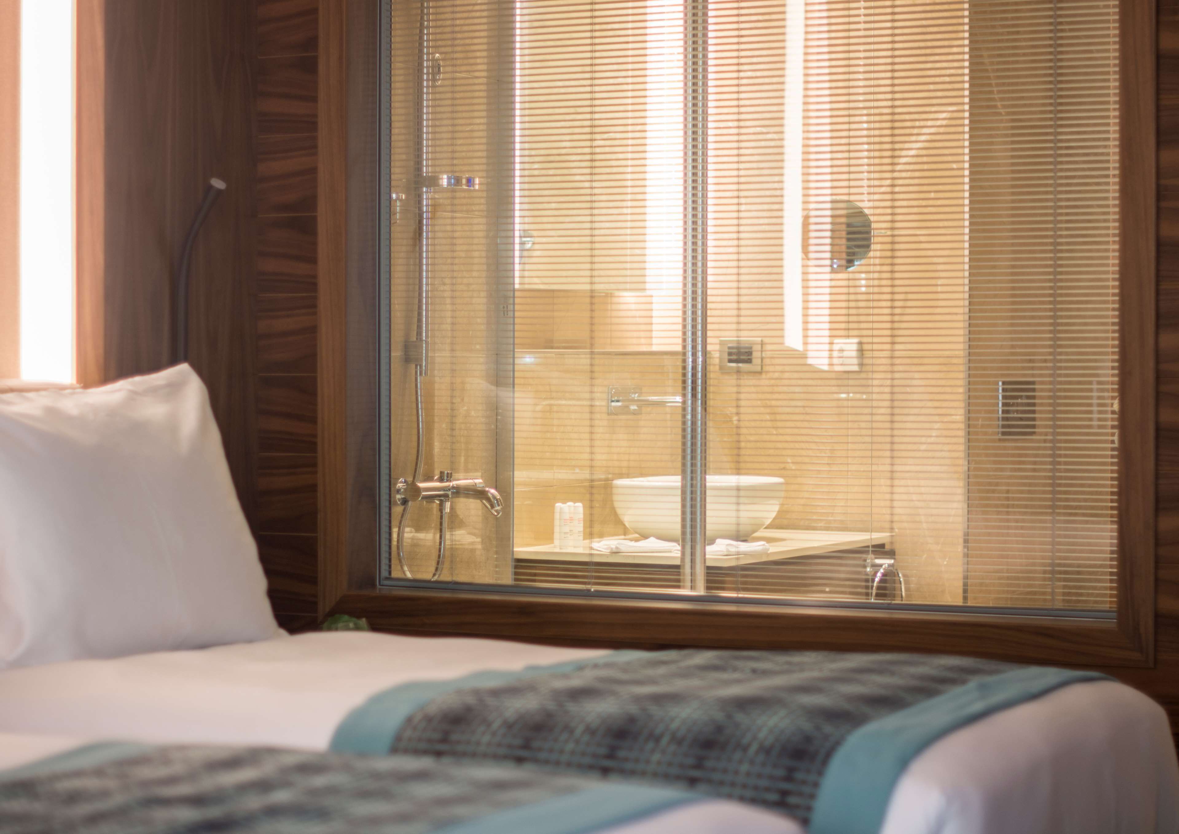 Une chambre d’hôtel avec une grande fenêtre, un lit et vue sur la salle de bain.