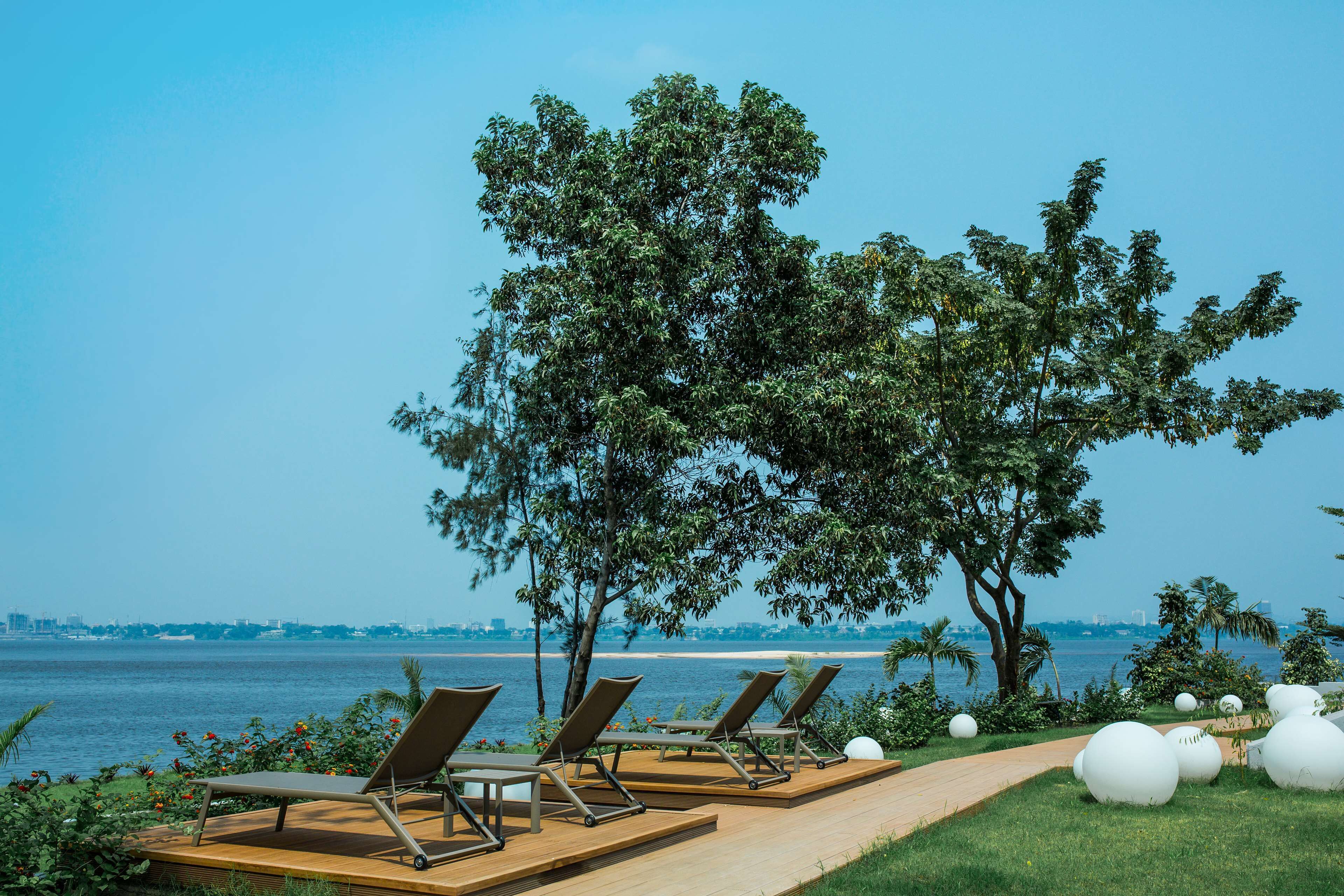 Un espace extérieur paisible, aménagé avec des fauteuils confortables et un sentier menant à la plage.