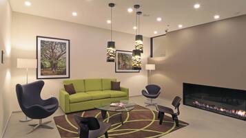 Una sala de estar moderna con un sofá verde, dos sillones, una mesa de centro y una chimenea.