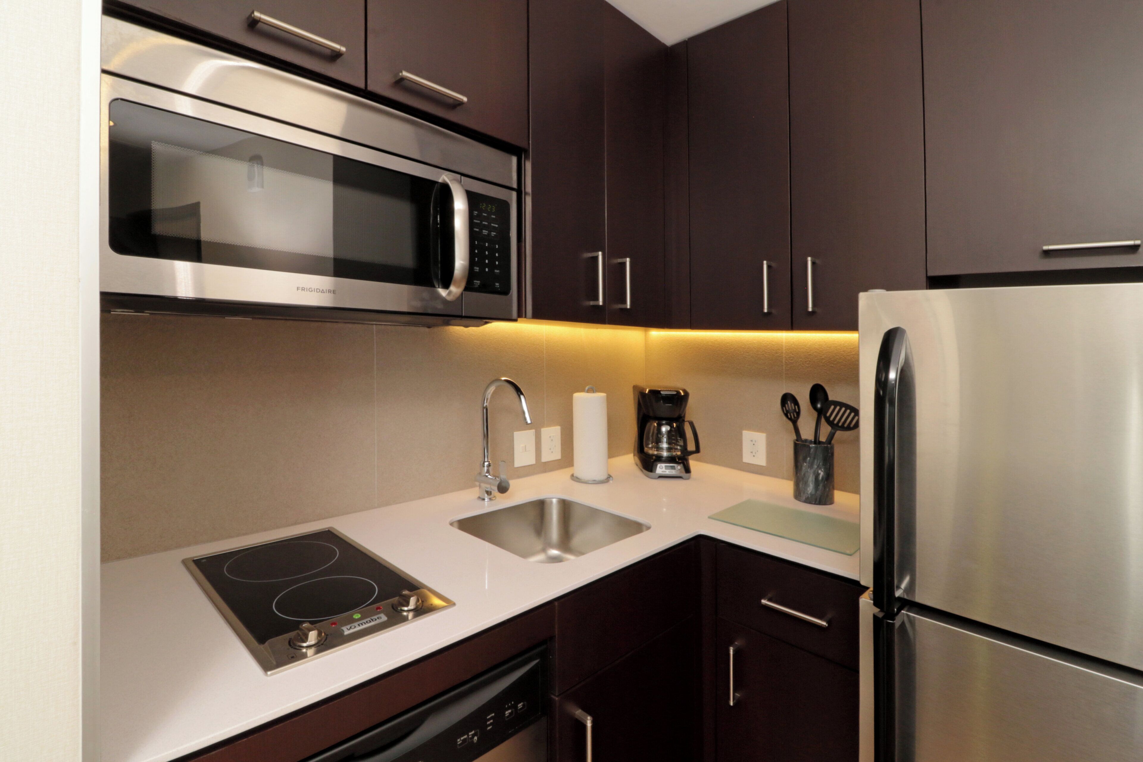 A modern kitchen with stainless steel appliances, including a microwave, oven, and refrigerator.