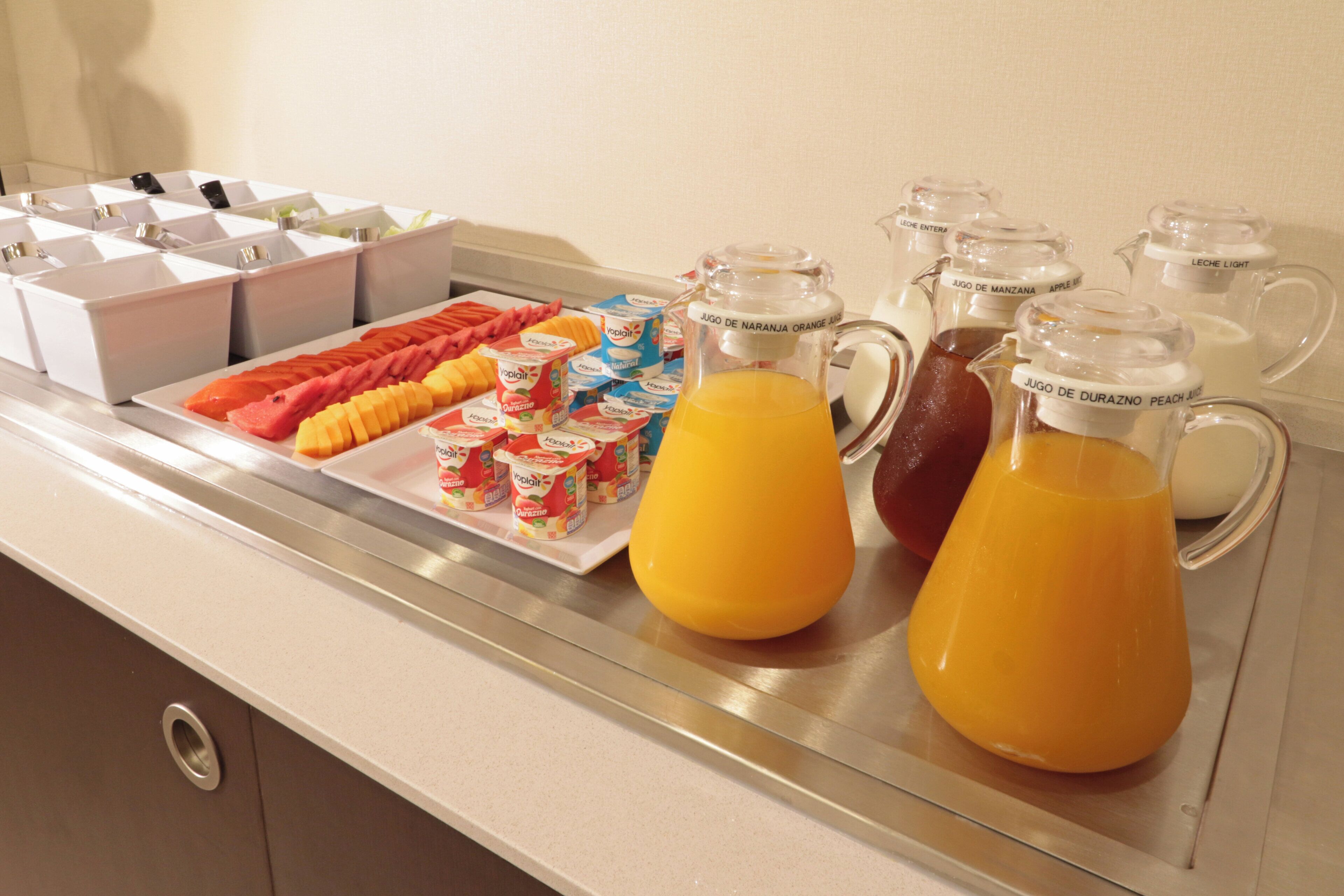 Disposição de buffet com diversos alimentos e bebidas.