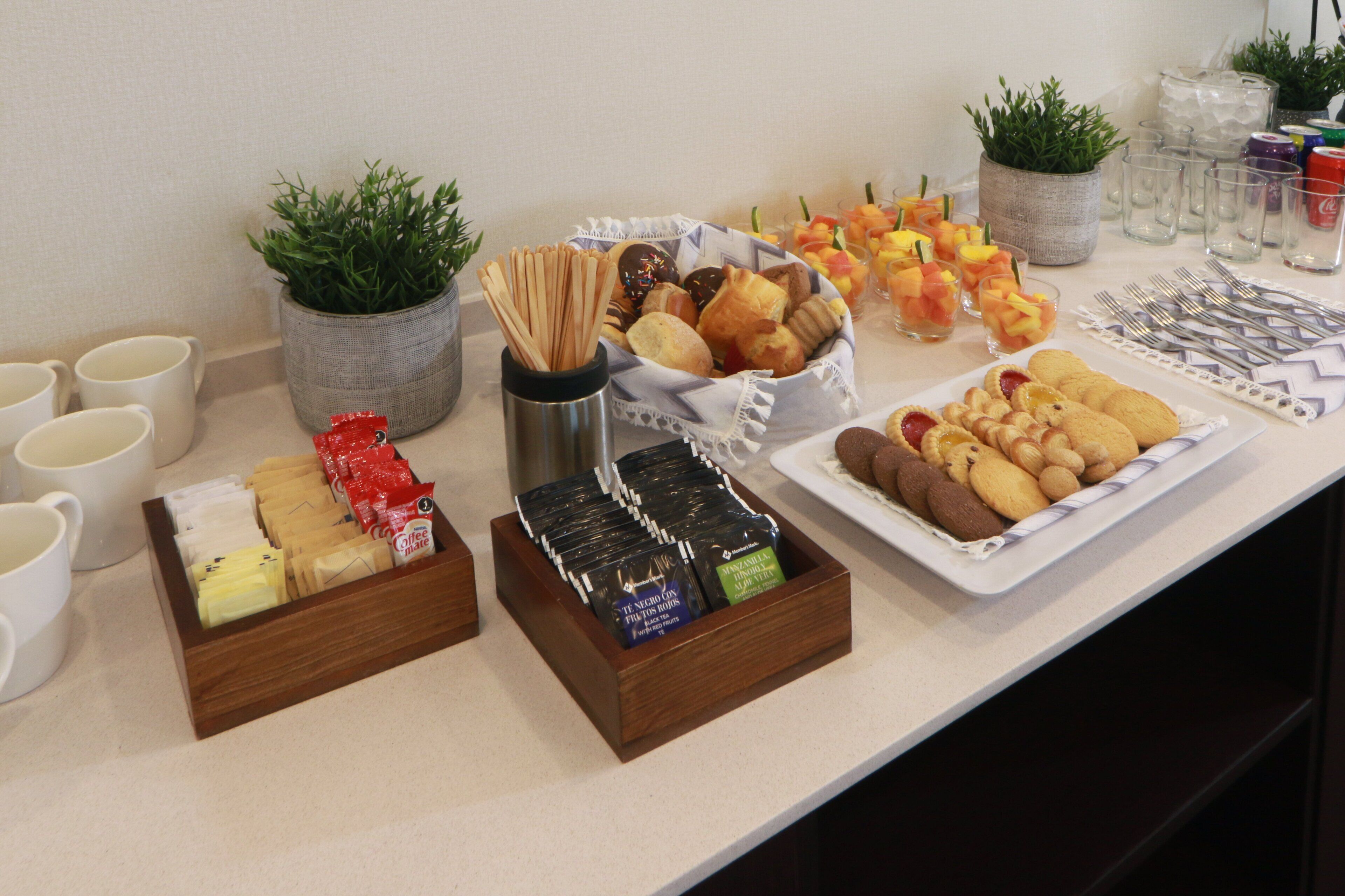 A buffet table with various food items and beverages.