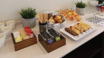 A buffet table with various food items and beverages.