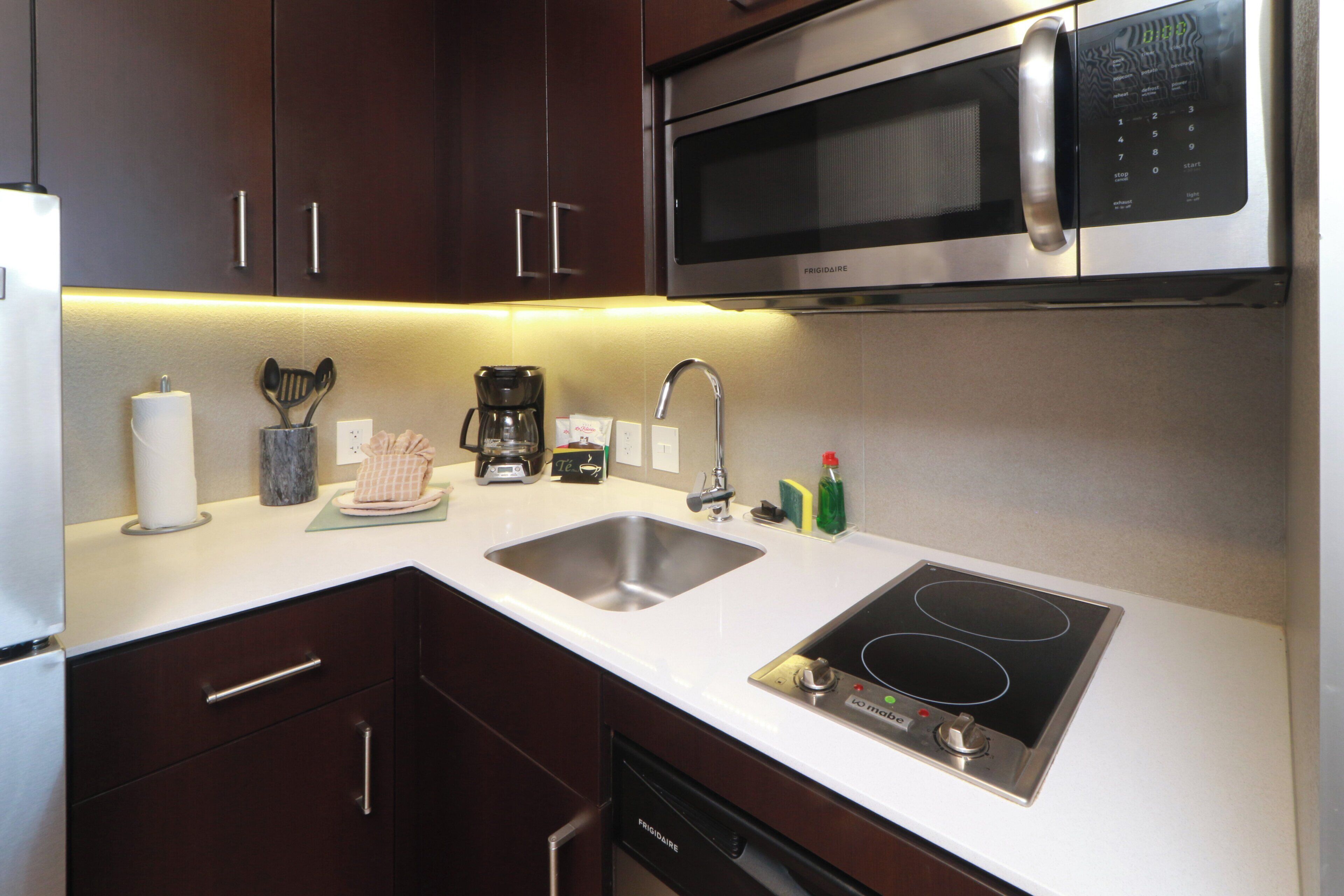 A modern kitchen with stainless steel appliances, a double sink, and a built-in stovetop.