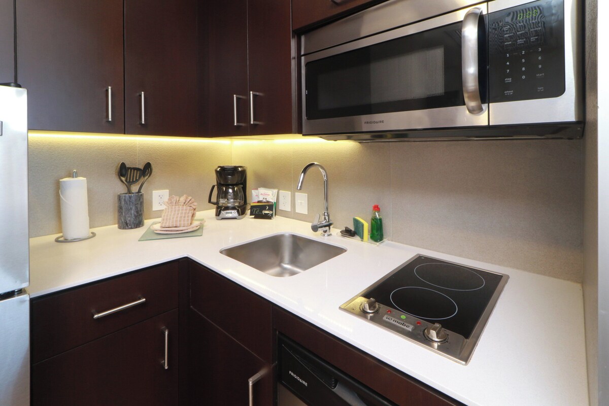 A modern kitchen with stainless steel appliances, a double sink, and a built-in stovetop.