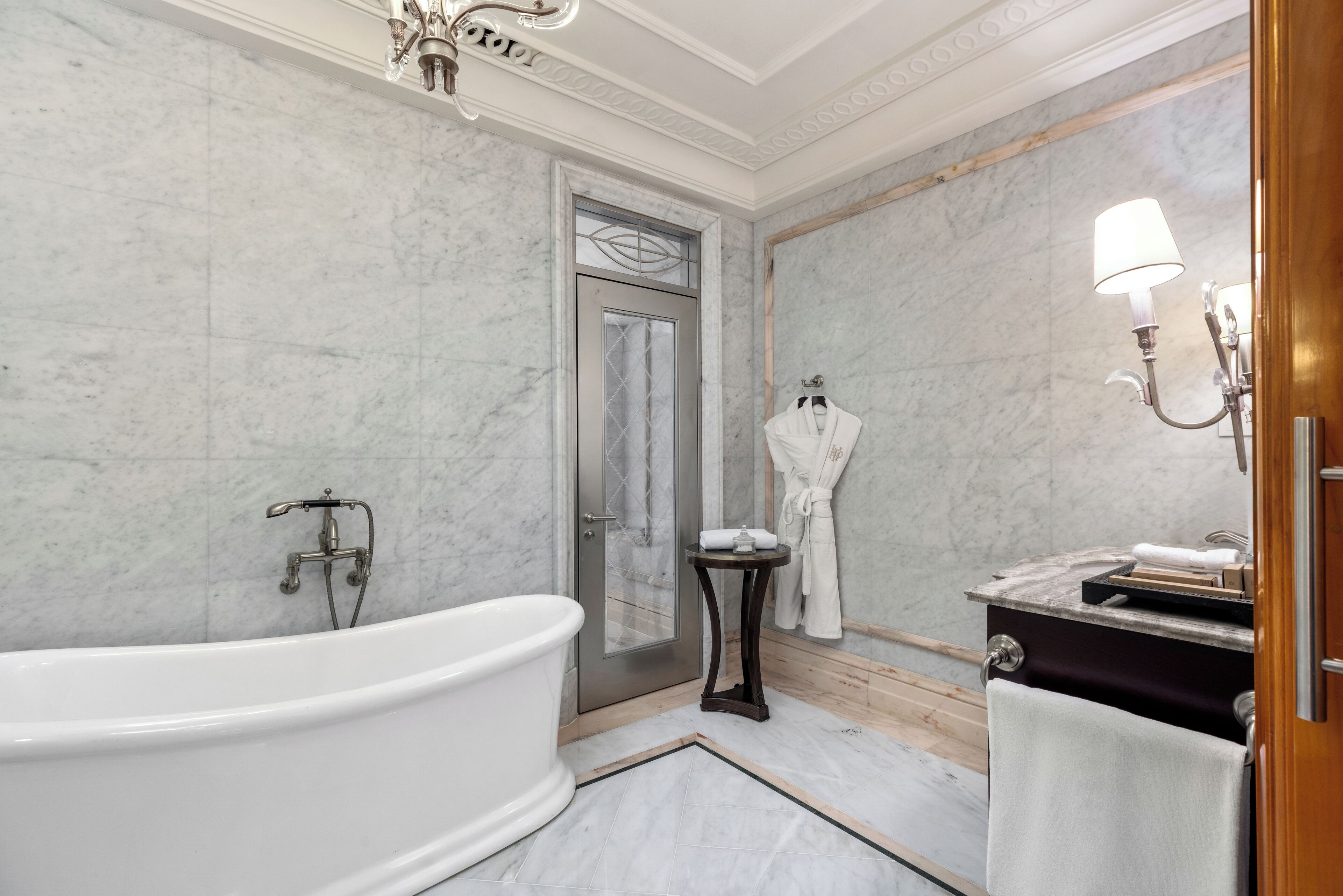 A modern bathroom with a freestanding bathtub, a vanity with a mirror and towel rack, and a shower area.