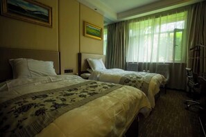 A hotel room with two beds, a painting on the wall, and a window with curtains.