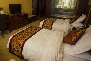 A hotel room with two beds, a TV, a desk, and a wardrobe.