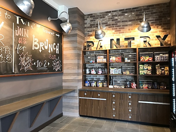 A restaurant's interior with a chalkboard menu, a pantry stocked with snacks, and a wooden counter. - Four Points By Sheraton Midland (Midland)