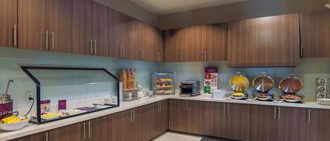 Eine moderne Küche mit Holzausbau, einer Selbstbedienungs-Frühstückstheke und einer Kaffeestation.