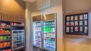 A vending area with snack and drink options, including refrigerated cases and a display of bottled water.