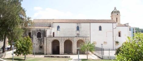 Un edificio histórico con un patio central, arcos y una torre de campanas.