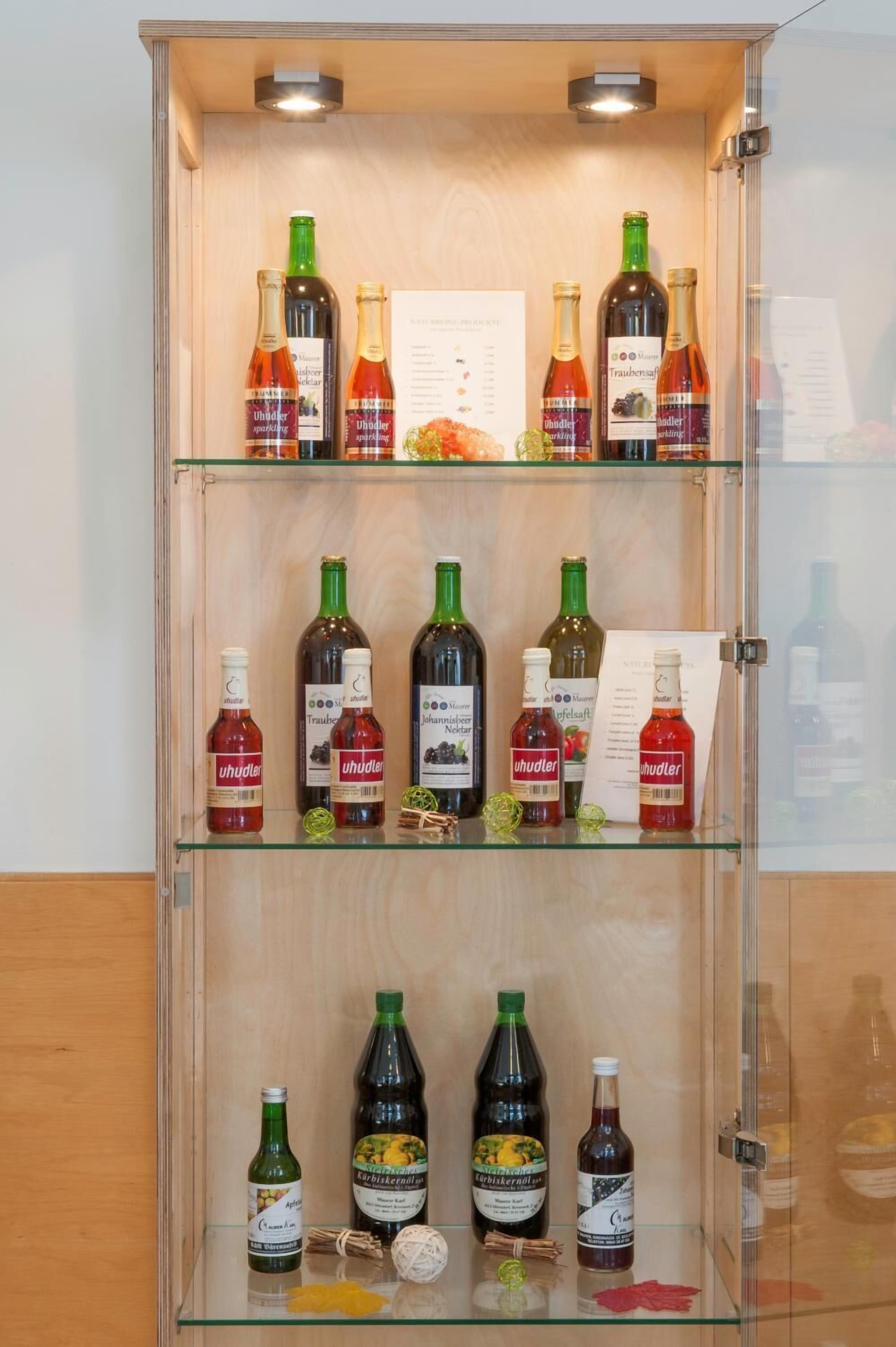 Eine Vitrine mit verschiedenen Weinflaschen, darunter 'Uhudler' und 'Traubenwasser'.