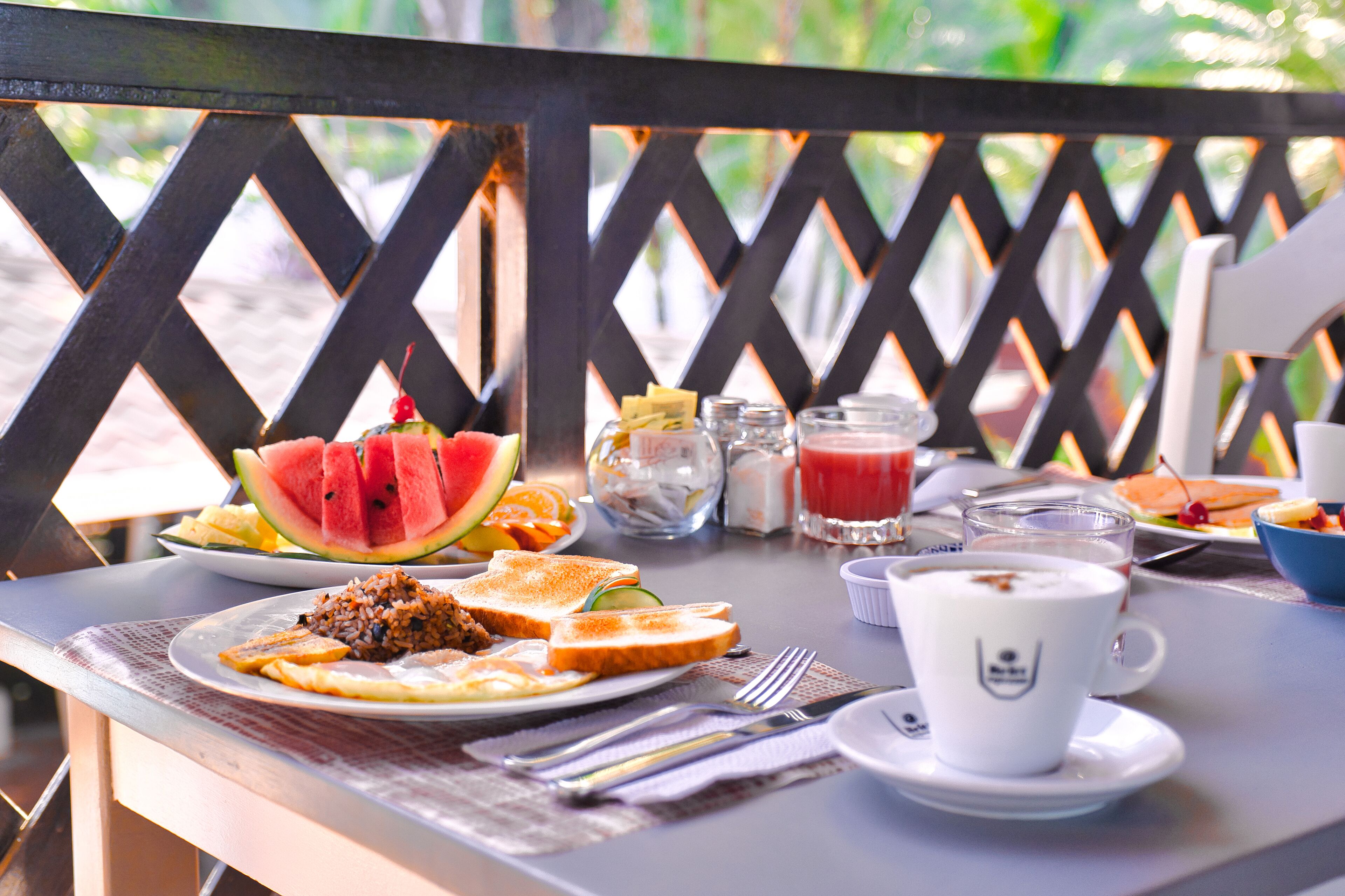 A table set with breakfast items including toast, fruit, and a cup of coffee.