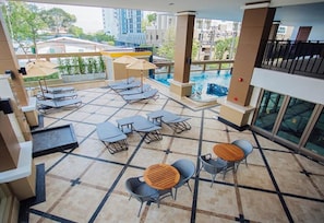 A rooftop pool area with lounge chairs and tables, a small pool, and a view of the surrounding buildings. - March Hotel Pattaya (Pattaya)