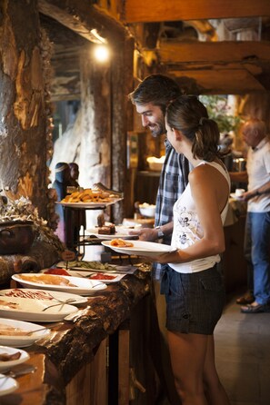 A buffet setup with various dishes and a wooden counter. - Huilo Huilo Reino Fungi (Panguipulli)