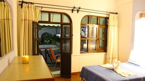 A hotel room with a bed, a small table, and a window with curtains. - Hotel Careyes Puerto Escondido (Puerto Escondido)