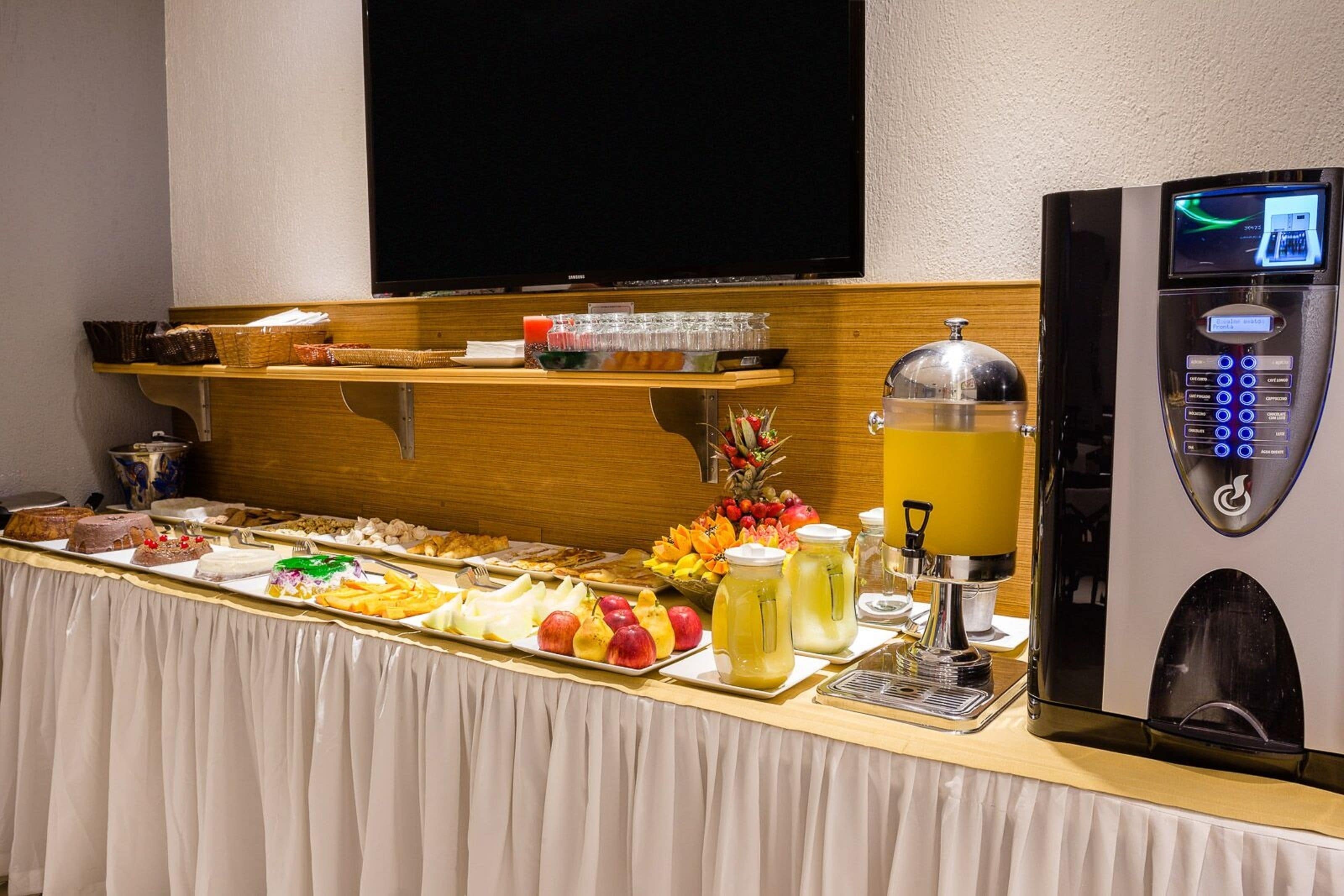 A buffet with various food items and a coffee machine.