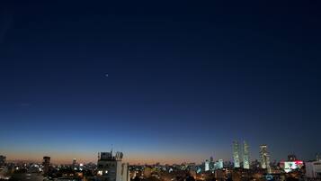Un horizonte urbano al anochecer con edificios iluminados y cielo despejado.