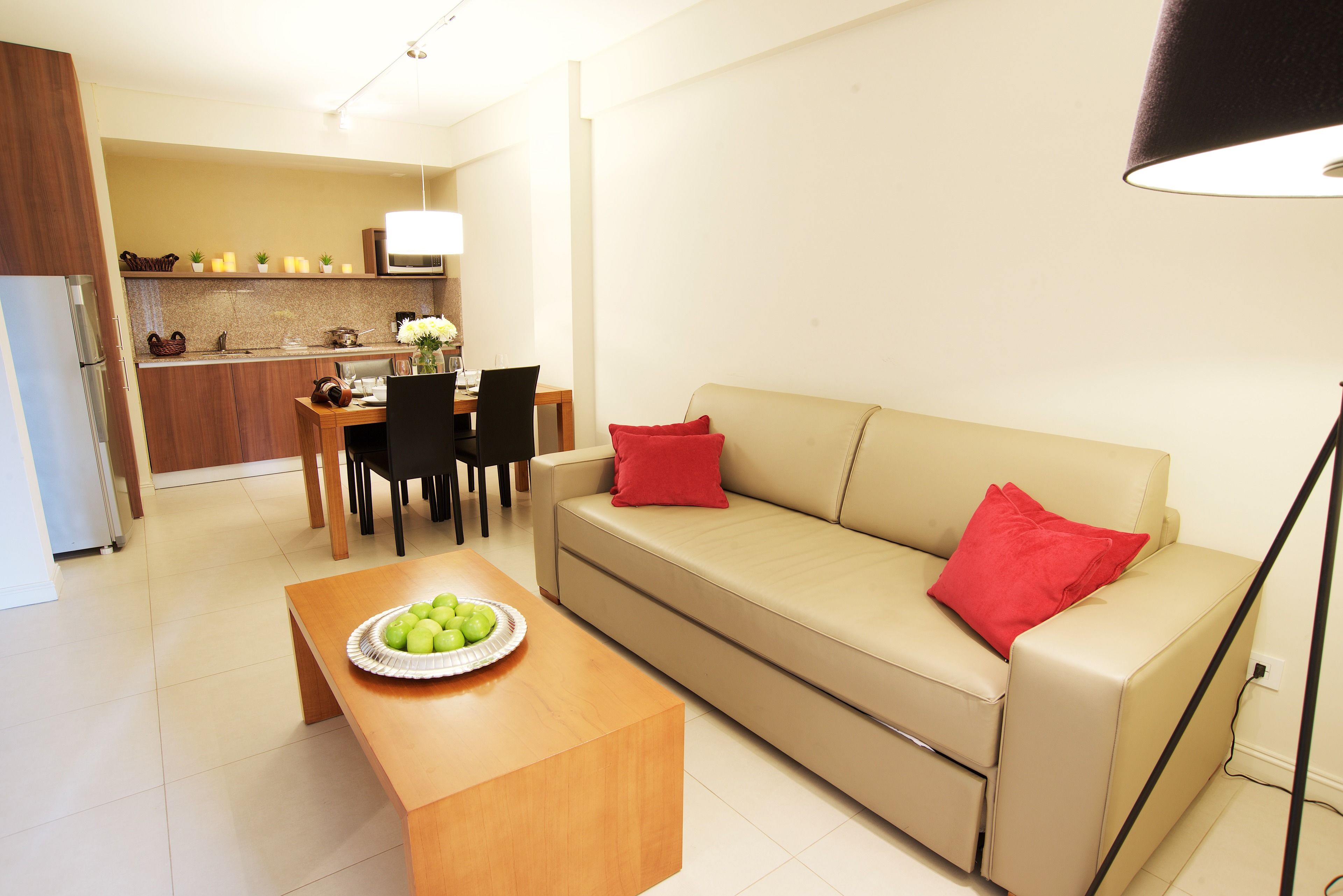 A living room with a sofa, a coffee table, and a dining area with chairs and a table.