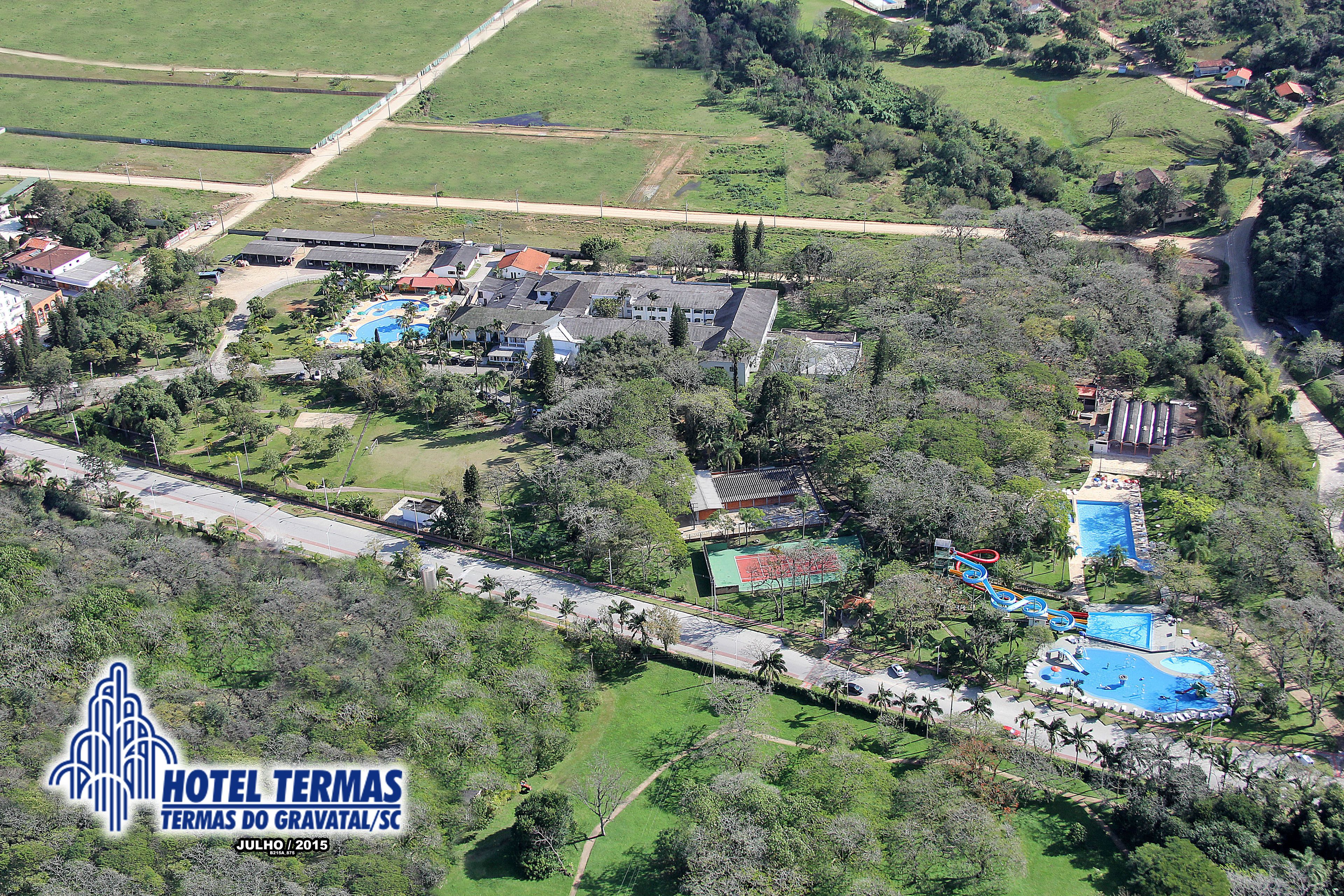 Luchtbeeld van Hotel Termas met een zwembad, tennisbanen en omliggend groen.