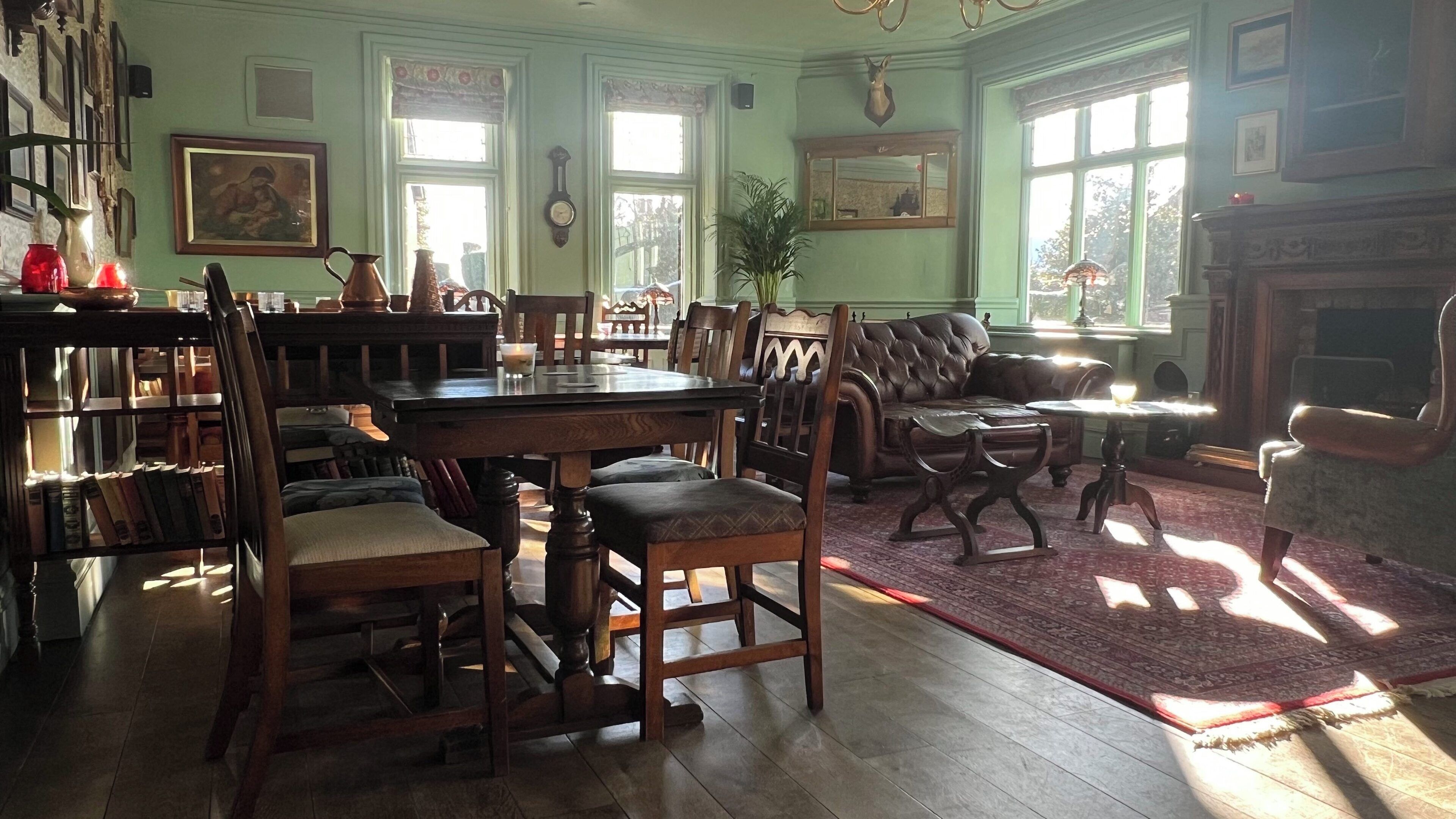 A traditional room with a dining table, chairs, a sofa, and a fireplace.