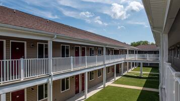Un motel à plusieurs étages doté d’une cour intérieure, comprenant une galerie couverte et des chambres individuelles avec balcon.