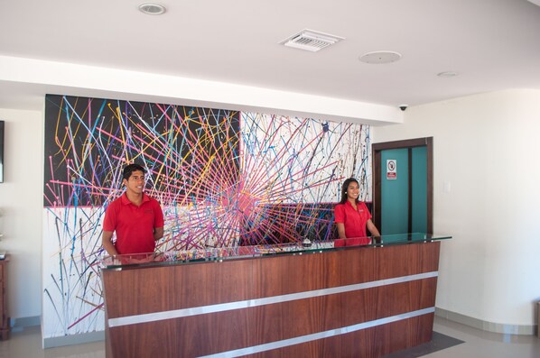A reception desk with a colorful abstract painting in the background.