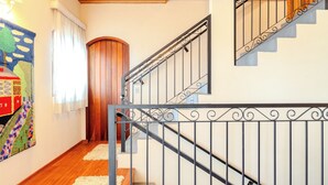 A staircase with a black metal railing and wooden steps. - Pousada Recanto Sião (Campos do Jordão)