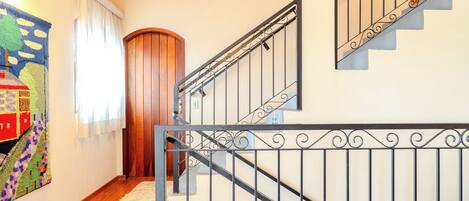 Una escalera con barandilla de metal negro y peldaños de madera.