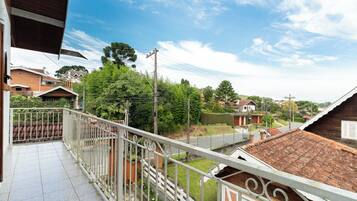 Un balcon avec une balustrade en métal donnant sur une rue résidentielle.