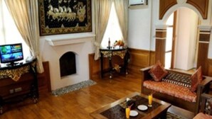 Un salón con chimenea, muebles de madera y televisor.