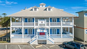 A two-story building with a balcony on each floor, a central staircase, and a parking lot in front. - St. George Inn (St. George Island)