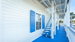A covered porch with blue steps leading to a white door. - St. George Inn (St. George Island)