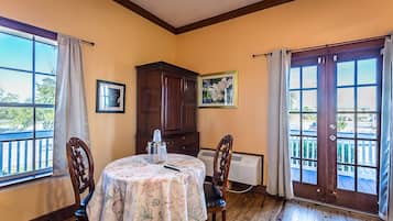 Un coin repas avec une table dressée pour deux personnes, un buffet en bois et un radiateur.