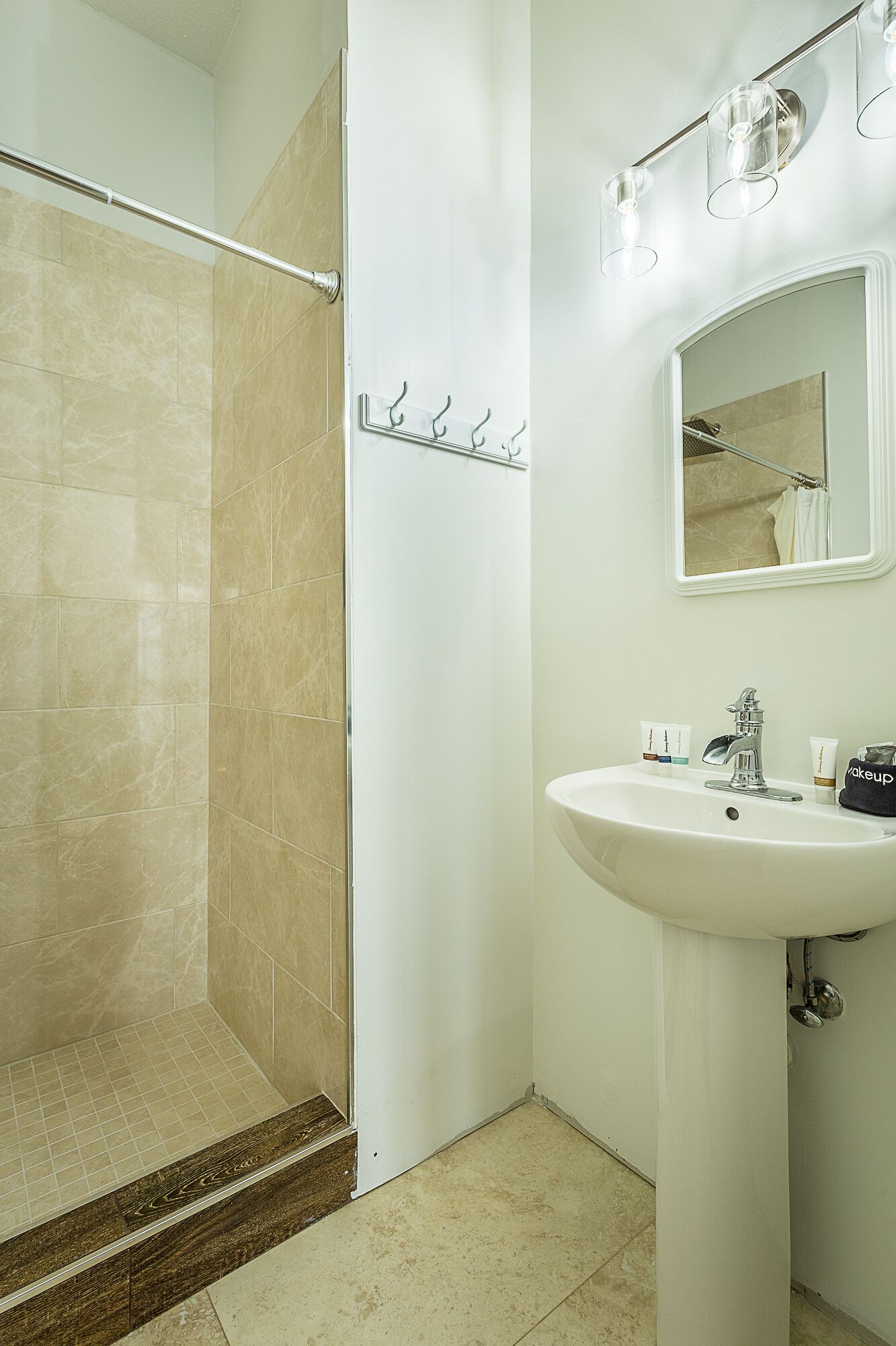 A bathroom with a shower, a sink, and a mirror.