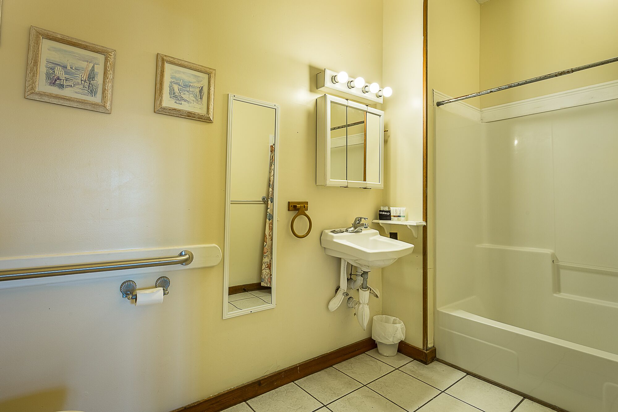 Een badkamer met een wastafel, spiegel, wastafelmeubel en douche.