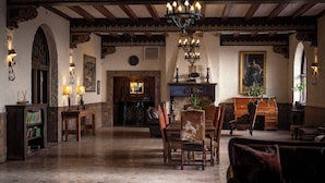 Una habitación tradicional con chimenea, muebles de madera y un candelabro.