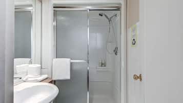 Un baño con ducha, lavamanos e inodoro.