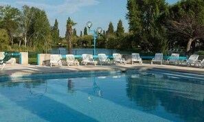 A swimming pool with white lounge chairs and a clear blue sky. - Club Village Camarguais (Arles)