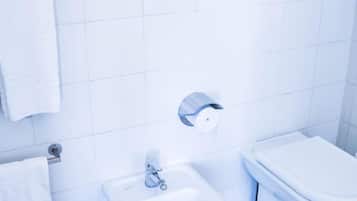 Un baño con bidé, inodoro y lavamanos.