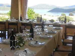 Enjoy meals with a view of the serene water and rolling hills from this dining area.
