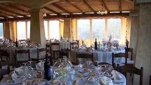 A restaurant with multiple round tables set for dining, featuring white tablecloths, wine glasses, and neatly folded napkins. - Funtana Abbas (Luras)