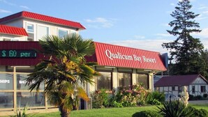 Un edificio con techo rojo y un letrero que dice 'Qualicum Bay Resort'.
