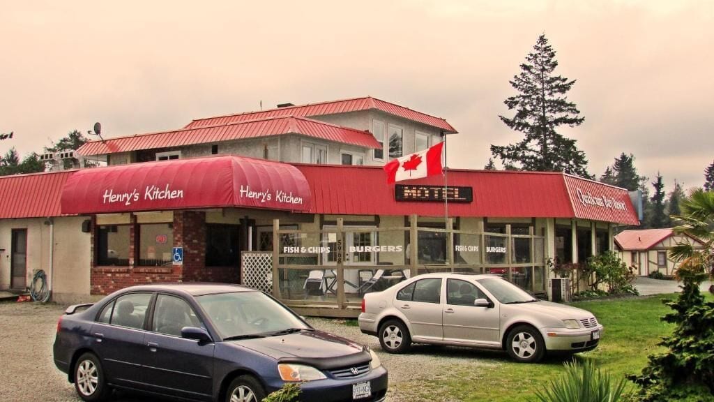 Un bâtiment doté d’un auvent rouge sur lequel on peut lire « Henry’s Kitchen » et d’un panneau indiquant qu’il s’agit d’un motel.