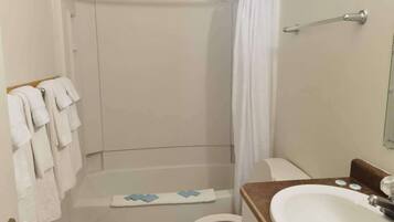 A bathroom with a shower, toilet, and sink.